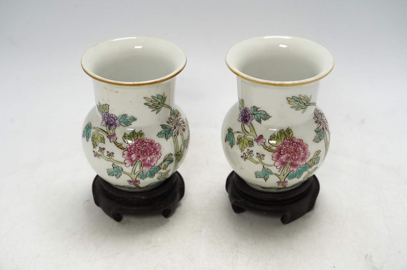 A pair of Chinese famille rose vases, mid 20th century, on wood stands, 10cm high. Condition - good